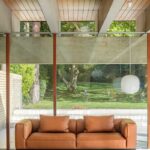 Brown couch in front of a large glass window